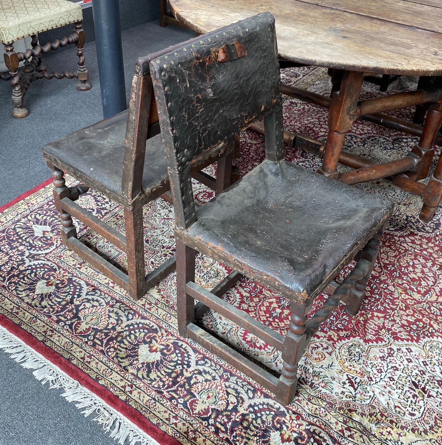 A harlequin set of six 17th century oak and leather dining chairs